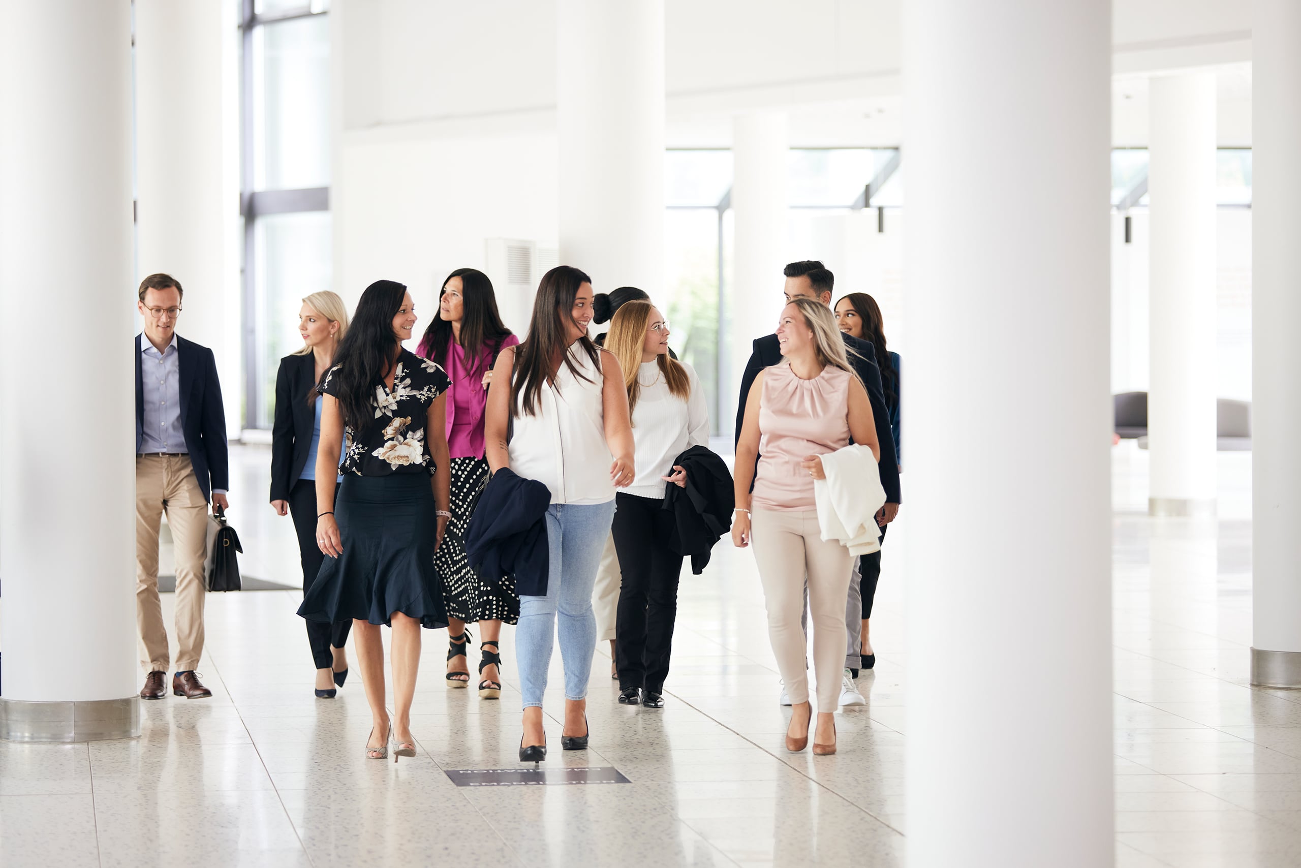 Menschen laufen in einer Gruppe durch einen Empfangsbereich