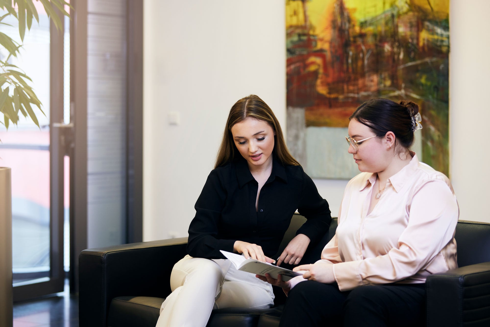 Frauen sitzen zusammen und lesen eine Broschüre