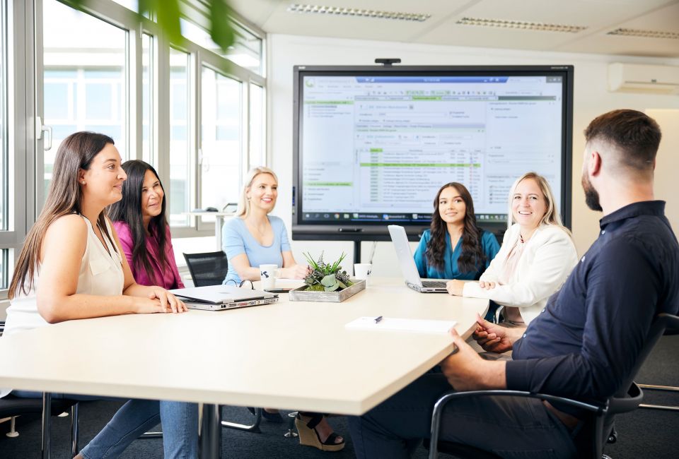 Team-Meeting in modernem Besprechungsraum mit Smartboard